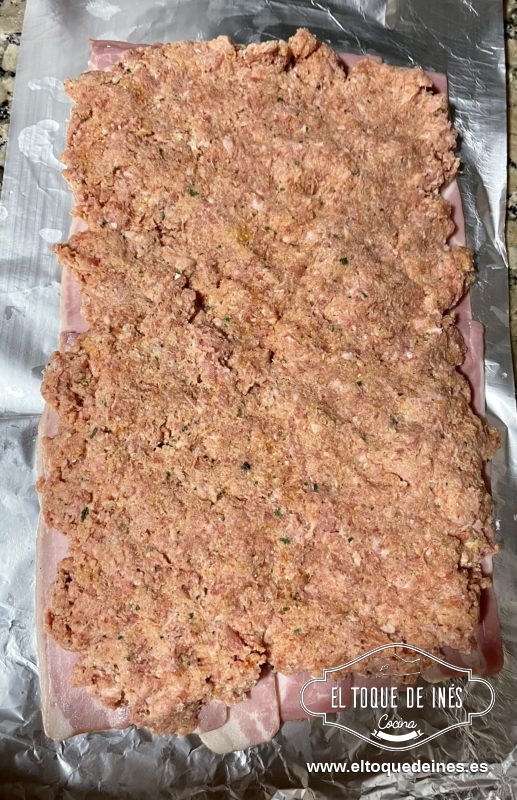 Repartimos la carne picada ya preparada encima del bacon dejando un borde libre por los cuatro lados.